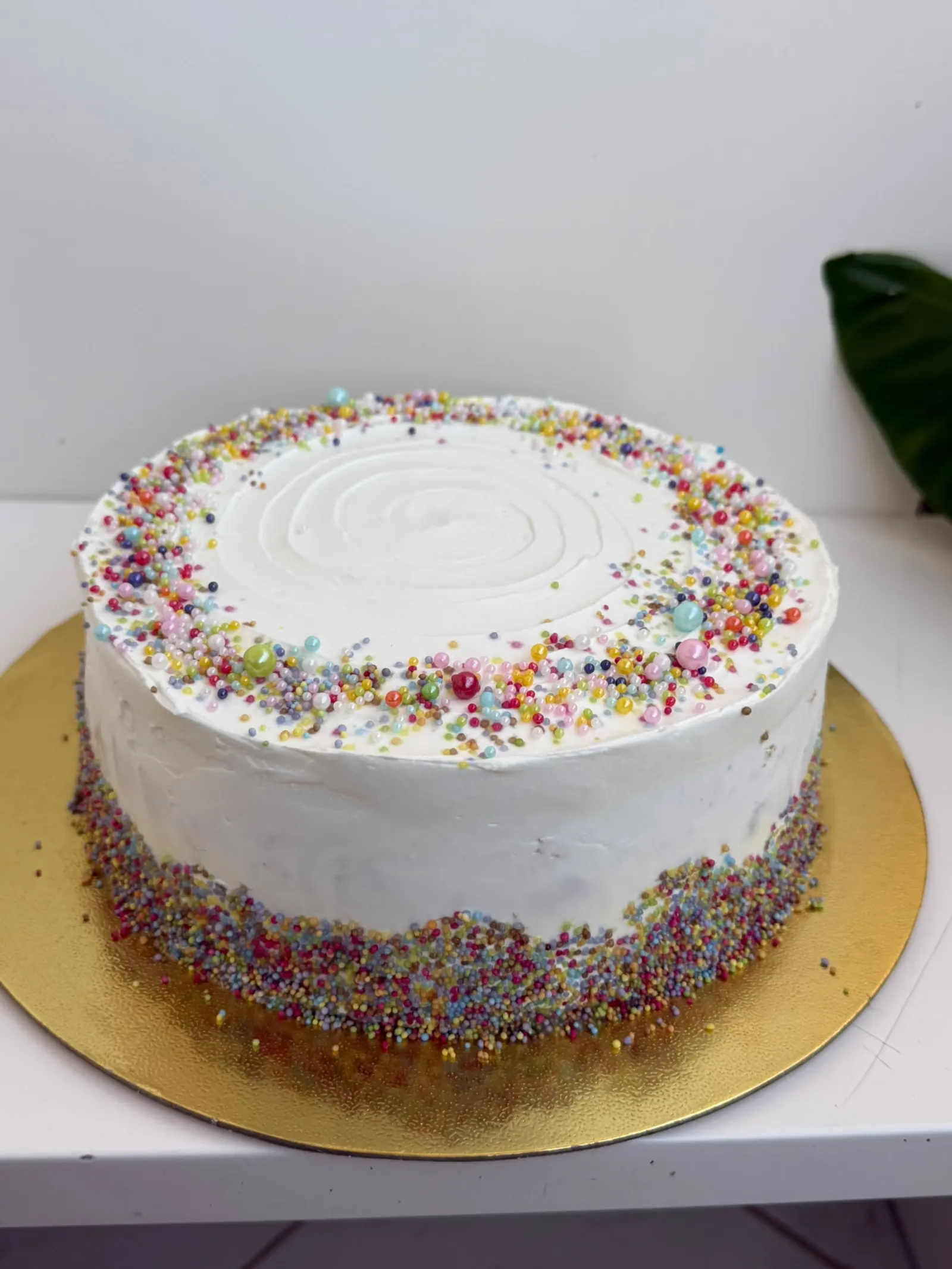 Bolo branco com bordas de confeitos coloridos