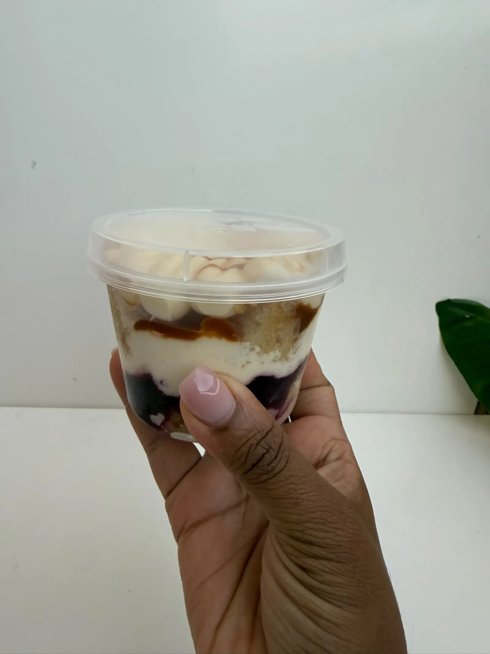 Copo de sobremesa em camadas com creme, caramelo e frutos vermelhos
